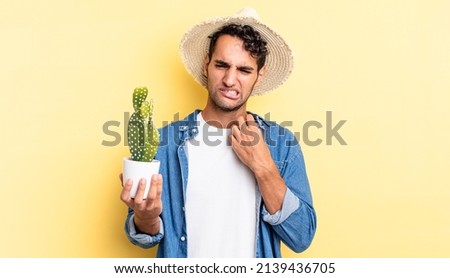 hispanic handsome man feeling stressed, anxious, tired and frustrated farmer and cactus concept