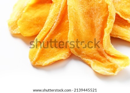 Dried sweet mango fruit slices as textural orange background in full screen