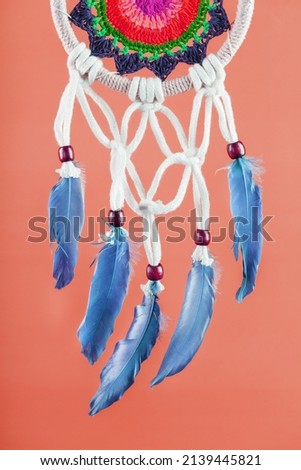 Amulet Dreamcatcher on a red background close-up protecting the sleeper from evil spirits and diseases