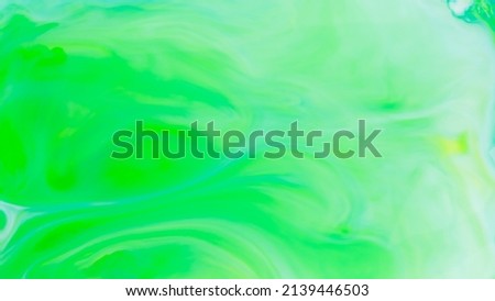 Fluid art background in green color. Green-turquoise stains on liquid. Creative background with blurred paints. Background for an eco-friendly concept