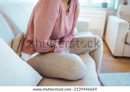 Cropped shot of an attractive young woman lying down on her bed and suffering from period pains at home. Ouch! My tummy! Woman with menstrual pain Royalty-Free Stock Photo #2139446669