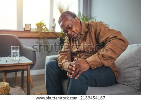 Senior man holds his hands up to his knees, knee pain, arthritis, arthrosis, meniscopathy, tendonitis. The concept of medicine, massage, physiotherapy, health. Royalty-Free Stock Photo #2139454187