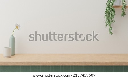 Minimal cozy counter mockup design for product presentation background. Branding in Japan style with wood top green counter and warm white wall with vase plant ceramic mug. Kitchen interior Royalty-Free Stock Photo #2139459609