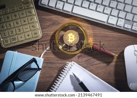 Bitcoin, calculator and other objects on the wooden table.