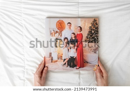 hands with a closed photobook on a white background. family photo shoot. professional printing of photos and albums in the printing, photo laboratory. photographer and designer services. memory.