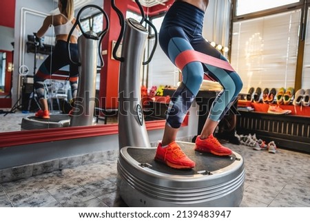 One woman training on the power plate machine female use powerplate for exercise legs and low section Royalty-Free Stock Photo #2139483947