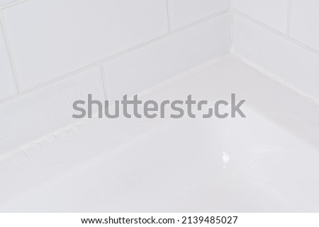 Waterproof joint filled with silicone sealant in the shower bath. Royalty-Free Stock Photo #2139485027