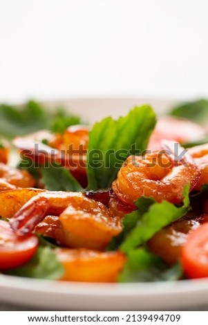 Close-up of fresh shrimp, tomato, arugula and greens salad, vertical image with copy space