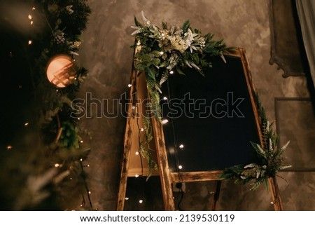 Slate board in the New Year's interior with a wreath and a garland