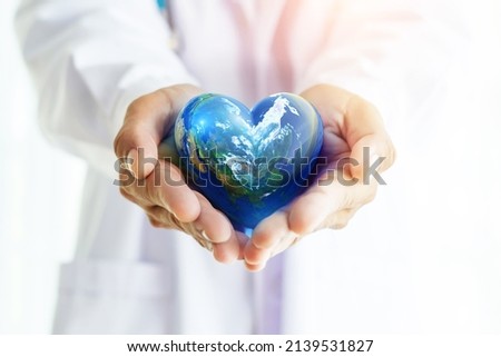 Hands hold Earth ball in heart shape on Doctor hands  for World Health Day content and copy space.Elements of this image furnished by NASA Royalty-Free Stock Photo #2139531827