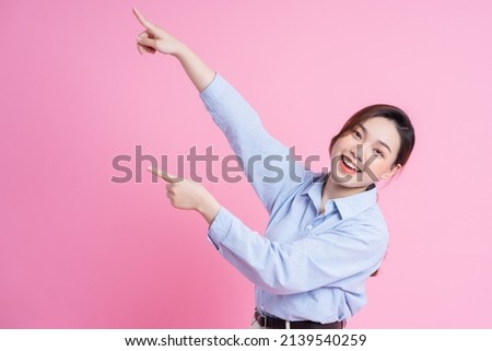Image of young beautiful Asian girl posing on pink background
