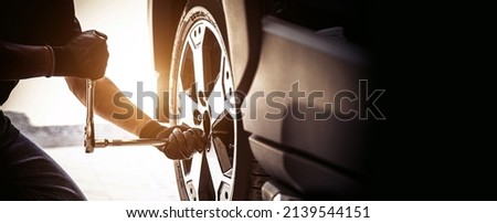 Auto mechanic use wrench to repairing and change car tires. Concept of car care service and maintenance or fix the car leaky or flat tire. Royalty-Free Stock Photo #2139544151