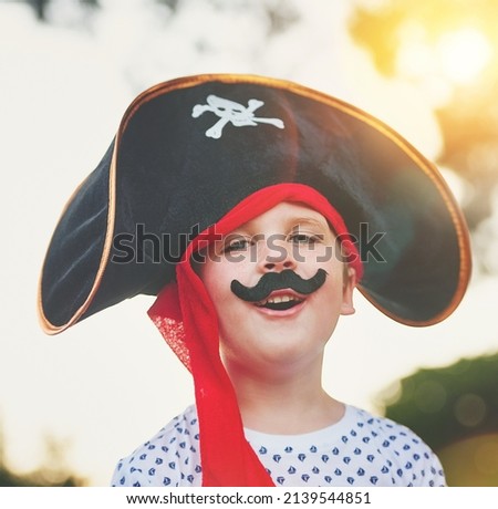 Yo ho, yo ho, a pirates life for me. Portrait of a cute little boy posing outside while dressed up like a pirate.