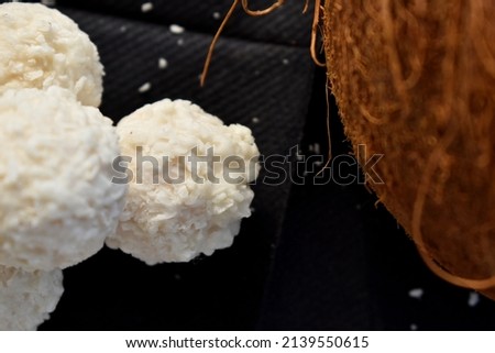 close up white chocolate truffles next to a coconut
