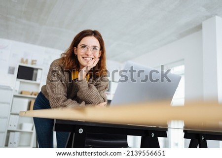 young modern business woman leaning on the desk and laughing Royalty-Free Stock Photo #2139556651