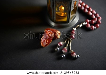 Close up of Arabian date fruits placed along with Egyptian lantern and Islamic Rosary. Ramzan background photo. Royalty-Free Stock Photo #2139565963
