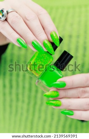Female hand with long nails and bright neon green nail polish