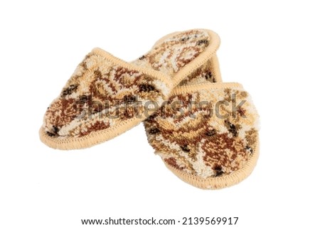 Homemade terry slippers in brown and beige tones. Isolated over white background. Close-up.
