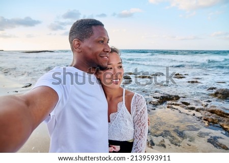 Happy couple in love taking selfie together on smartphone, on beach