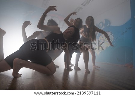 Young group of multiracial friends dancing enjoying and dancing together while improvising dance moves