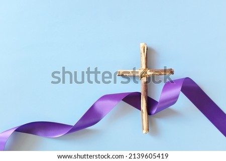 Top view flat lay of wooden cross crucifix with violet purple ribbon cloth with copy space. Holy week, lent season, Catholicism and Christianity concept. Royalty-Free Stock Photo #2139605419