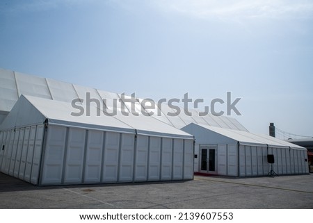 A huge tent in a grass field under sunny sky Royalty-Free Stock Photo #2139607553