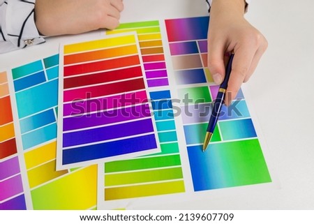 Woman's hand chooses a color on a color palette
