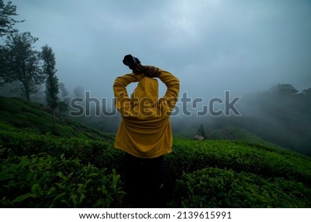 Photographer taking picture of misty morning nature, awesome foggy weather in Munnar, Travel and tourism concept image