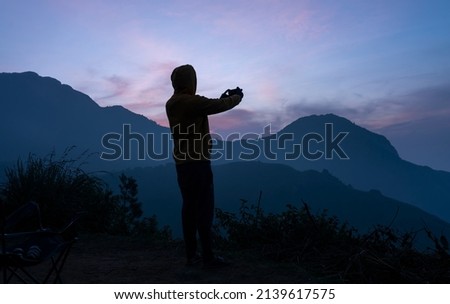 Travel photographer taking nature picture with his mobile phone, travel and tourism concept image