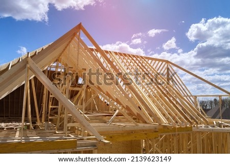 Timber frame house of gables roof on stick built home under construction new build roof with wooden beam framework Royalty-Free Stock Photo #2139623149