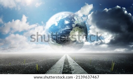 Planet Earth. Planet stands on the road and under a clear sky. Peace concept. Close up view from asphalt level. A green sprout growing from cracks in the aspha