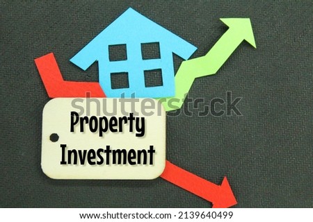 paper houses, fluctuating arrows and wooden tags with the words PROPERTY INVESTMENT