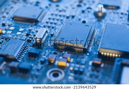 Computer Microchips on Electronic circuit board. Technology microelectronics concept background. Macro shot, selective focus, extremely shallow DOF. Noises and large grain - stylization under film. Royalty-Free Stock Photo #2139643529