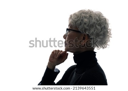 Silhouette of thinking elderly Asian woman. Royalty-Free Stock Photo #2139643551