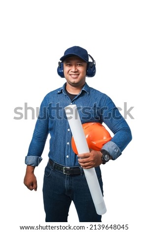 Young engineer standing holding helmet, blueprint and wearing ear muff wearing long sleeves and long pants standing smiling happy isolate on white background with clipping path.