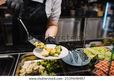 The waiter man or woman puts the food on a plate. Breakfast buffet concept, brunch with Family. People catering buffet food indoors in a luxury restaurant. Catering and Dining. Celebration party. Royalty-Free Stock Photo #2139648487