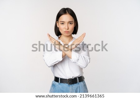 Image of young asian, korean girl student showing stop, cross prohibition sign, forbid smth, refusing, standing over white background Royalty-Free Stock Photo #2139661365