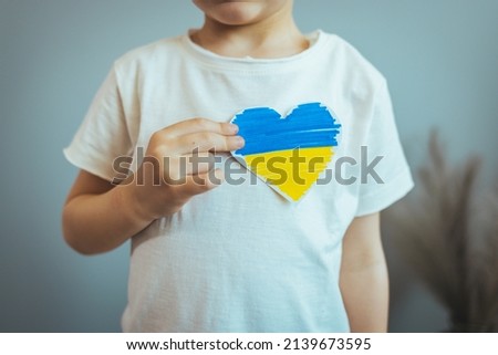 Hand holding a heart made from the flag of Ukraine blue yellow on an isolated white background. Concept of victory of Ukraine, independence of Ukraine. Patriotism and love for the country. My homeland