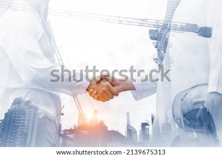 Double exposure  of business Arab man handshake on building construction background, good deal, well collaboration concept, selective focus.
