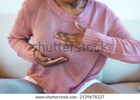 Young African American woman palpating her breast by herself that she concern about breast cancer. Healthcare and breast cancer concept. Mature woman doing self breast exam at home Royalty-Free Stock Photo #2139678227