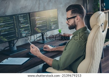 Photo of smart clever young man wear green shirt spectacles coding computer program typing modern device indoors workshop workstation. Royalty-Free Stock Photo #2139679253