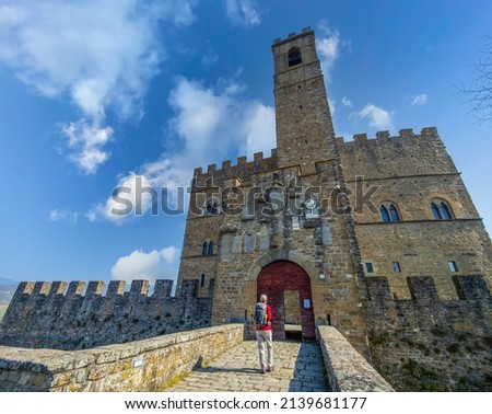 Woman entering Poppi Castle (Castello dei Conti Guidi) in Poppi - Casentino, Tuscany, Italy. Sunny spring day