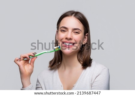 Portrait of a smiling cute woman holding toothbrush. Smiling woman with healthy beautiful teeth holding a toothbrush. Dental health background. Close up of perfect and healthy teeth with toothbrush. Royalty-Free Stock Photo #2139687447