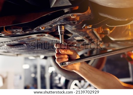 Auto mechanic checking running gear of automobile on service station. Male worker fixing problem with car. Vehicle maintenance concept Royalty-Free Stock Photo #2139702929