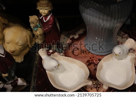 Photograph of bird objects in white, vase object in blue, angel object and puppy dog object Royalty-Free Stock Photo #2139705725