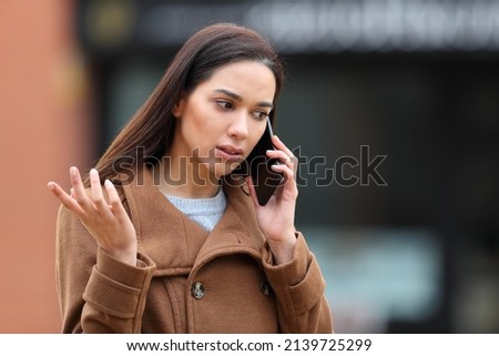 Angry woman in the street talking on mobile phone complaining Royalty-Free Stock Photo #2139725299