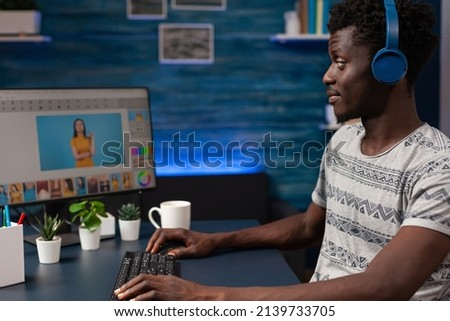 Photographer artist man sitting at desk retouching photo editing contrast using post production software in creativity studio. Professional illustrator working at picture correction remote from home