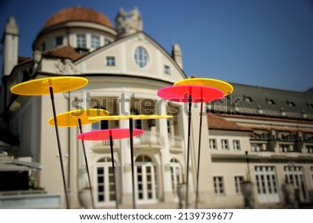 little colorful plastic disks capturing sunlight in front of a big palace