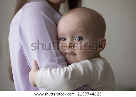 Close up head shot loving young woman cuddling sweet adorable small newborn baby toddler boy or girl with big grey eyes, expressing sincere feelings, enjoying tender moment, childhood and motherhood. Royalty-Free Stock Photo #2139744623