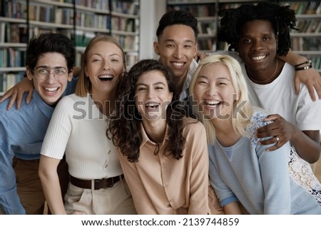 Six happy multi ethnic students laughing pose look at camera standing hugging in college library. Excellent study in university, education in higher institution, multiracial friendship, unity concept Royalty-Free Stock Photo #2139744859